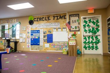 Brighten Academy classroom circle time area with rainbow dots on the floor and educational materials on the wall