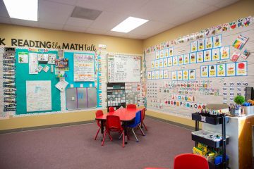 Brighten Academy classroom with red table and learning materials covering the walls