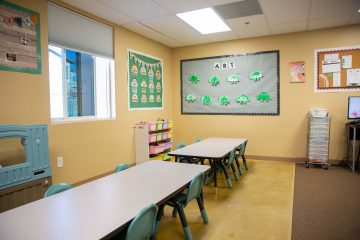 Brighten Academy classroom with tables and student art on the wall
