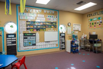 Carpet time area of a Brighten Academy Preschool classroom with learning materials on wall