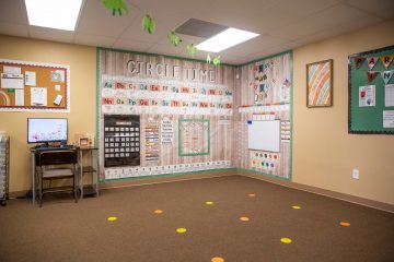 Classroom circle time area with learning materials on the walls